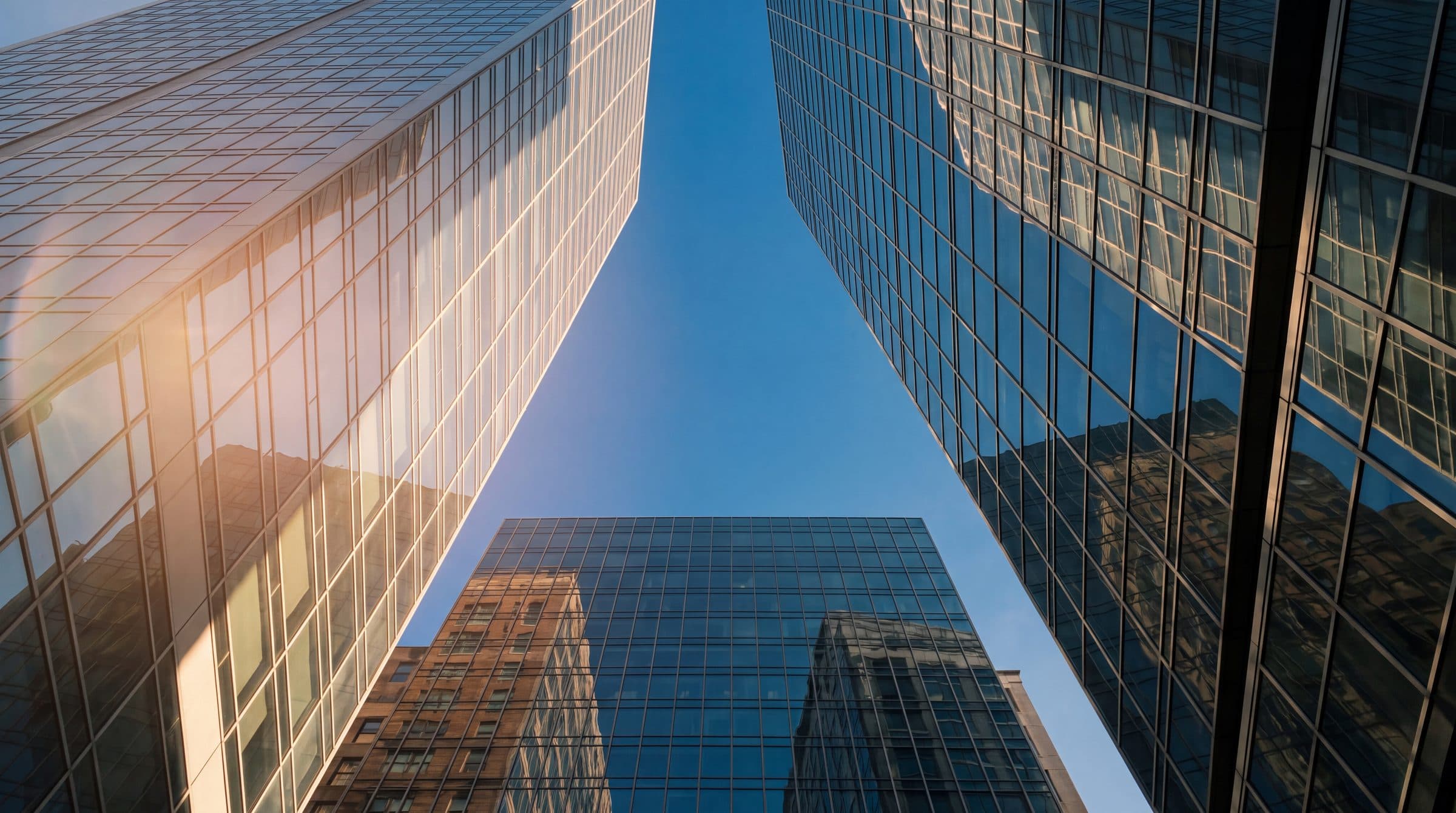 Glass office towers against a blue sky